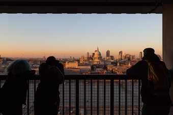 Photograph of visitors on the viewing platform at Tate Modern looking at the view across the River Thames 