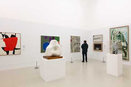 a person stands to look at art in a gallery space