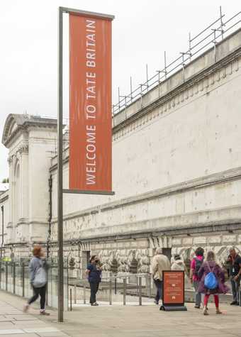 the sSide entrance view of Tate Britain at the top of a ramp with a sign that reads 'welcome to Tate Britain'