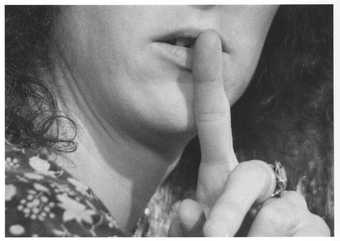 A women holds a finger up to her lips