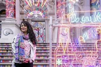 Chila Kumari Singh Burman stands in front of her artwork at Tate Britain 