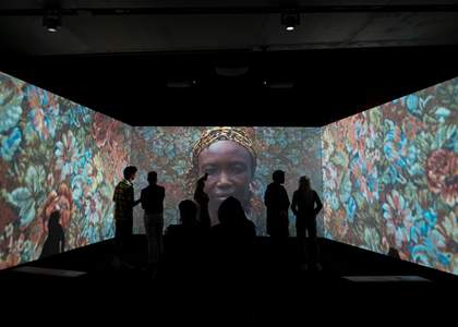 Three screen with the shadows of viewers in front.