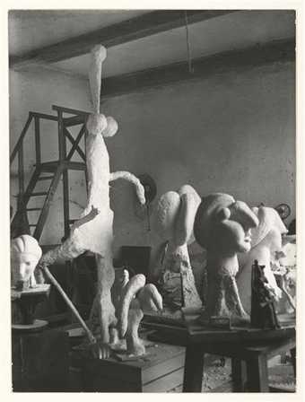 A black and white photograph of sculptures in a studio