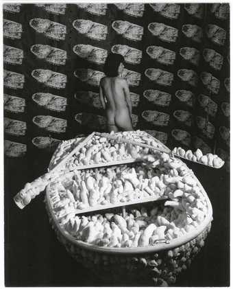 Yayoi Kusama posing at her Aggregation: One Thousand Boats show installation in the Gertrude Stein Gallery, New York 1963