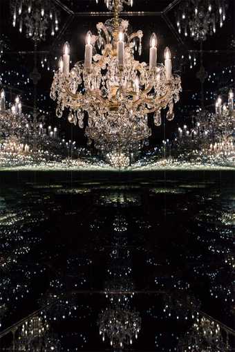 A chandelier reflected in dark mirrors to infinity