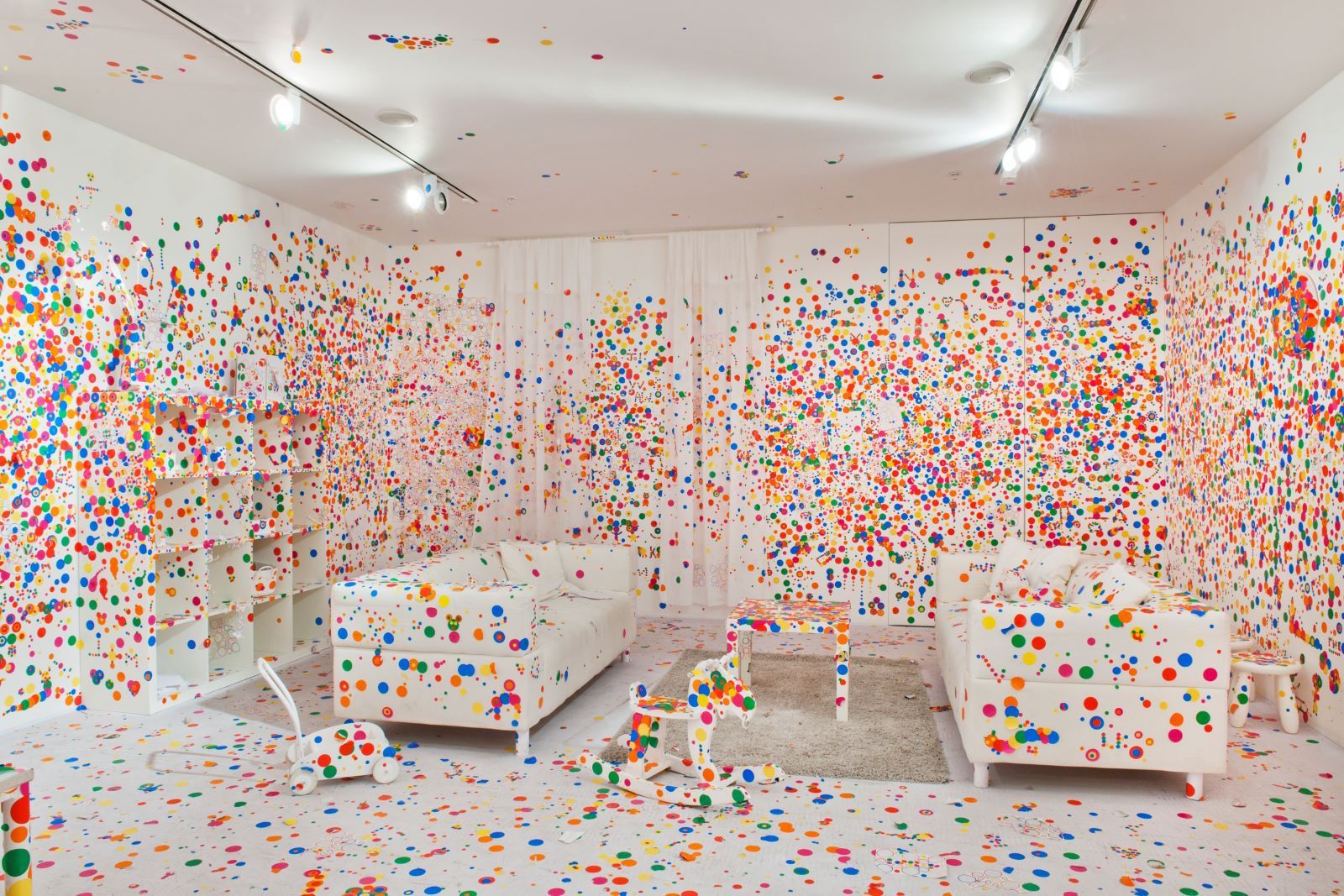 A white room covered in colourful dots